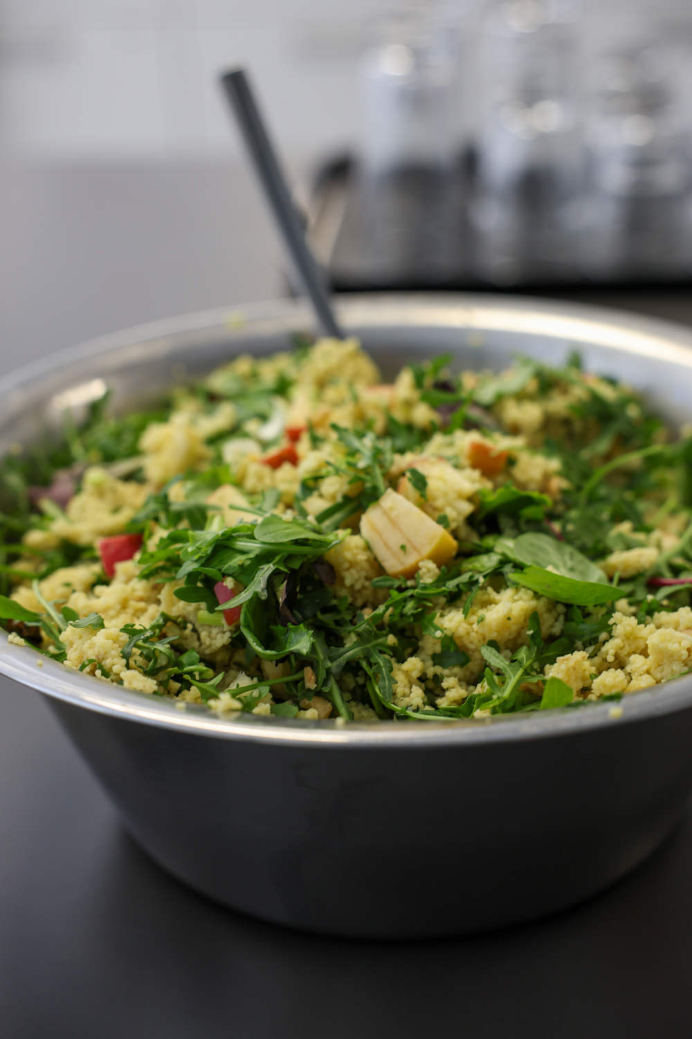Das Bild zeigt eine große Schüssel Couscous-Salat mit u.a. Rucola, Äpfeln und Walnüssen.
