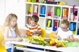 Schüler und Schülerinnen bereiten gesunde Snacks aus Obst und Gemüse zu