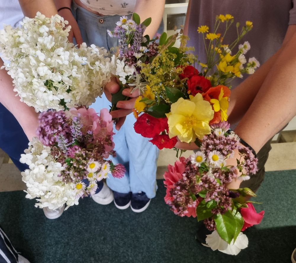 Schüler halten Blumensträuße in den Händen